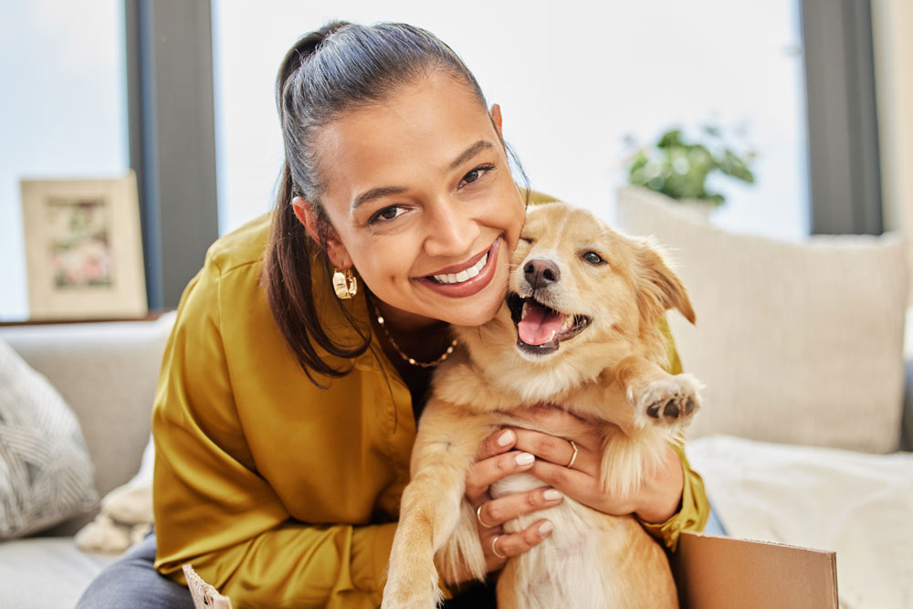 Young woman sitting with her dog, enjoying clear vision after being approved for LASIK candidacy.