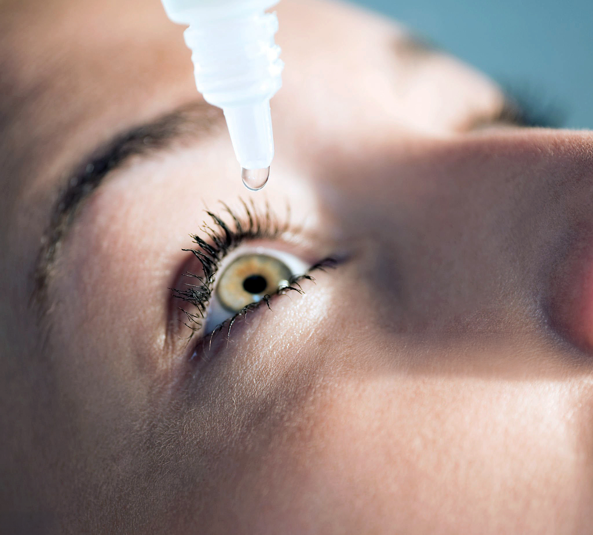 Close-up of a patient applying eye drops as part of their cataract surgery recovery routine.