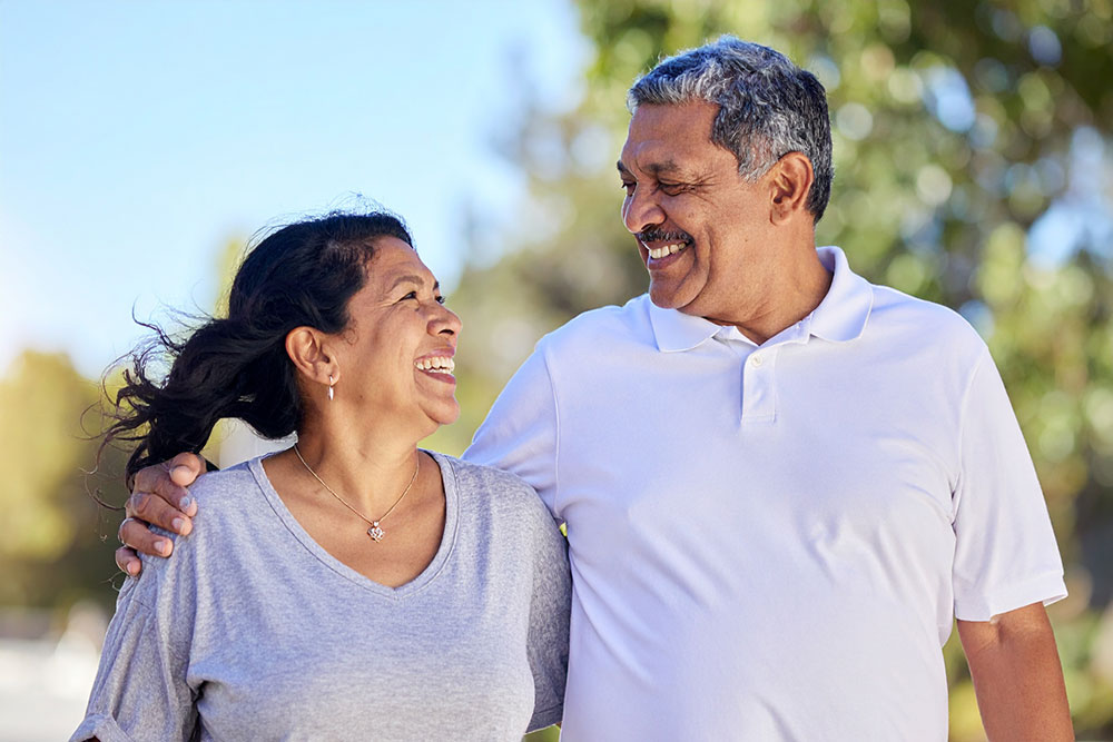 Mexican couple discussing cataract surgery cost and options while walking outside.