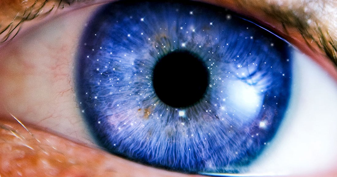Close-up blue iris with starry reflections illustrating how space travel affects eyesight (SANS)