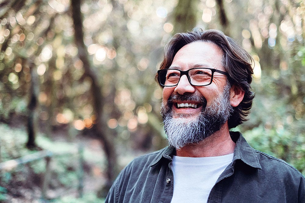 Happy older man wearing glasses and enjoying the outdoors after presbyopia treatment