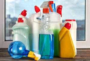 Assorted household cleaning products in colorful bottles, representing common chemical hazards that can cause eye injuries in children