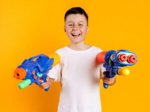 Child holding toy water guns, highlighting the importance of eye safety during play