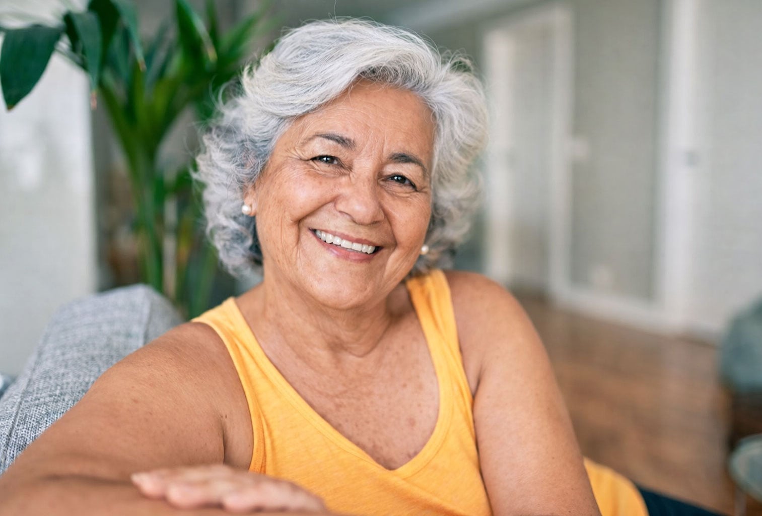 Senior Hispanic woman happy at home after learning what to expect after cataract surgery from Southwest Eye Institute.