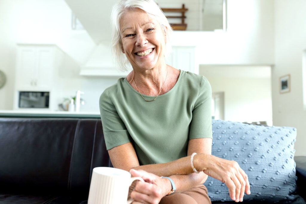 Smiling senior woman at home enjoying clear vision after cataract surgery