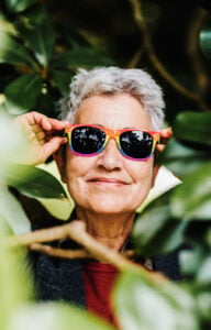 Older adult adjusting colorful UV400 sunglasses outdoors—sunglasses after cataract surgery